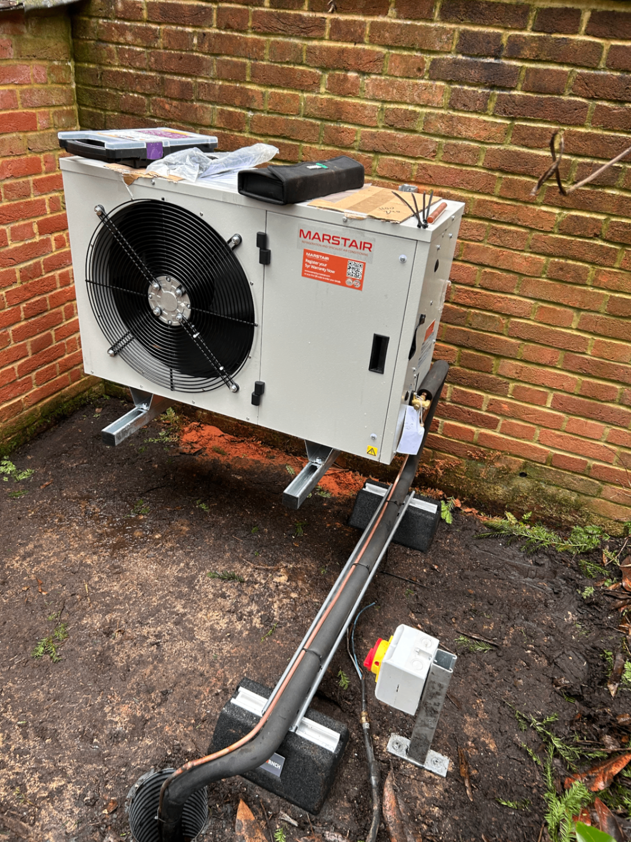 Marstair outdoor condenser unit installed on brackets against a brick wall at a Wandsworth property