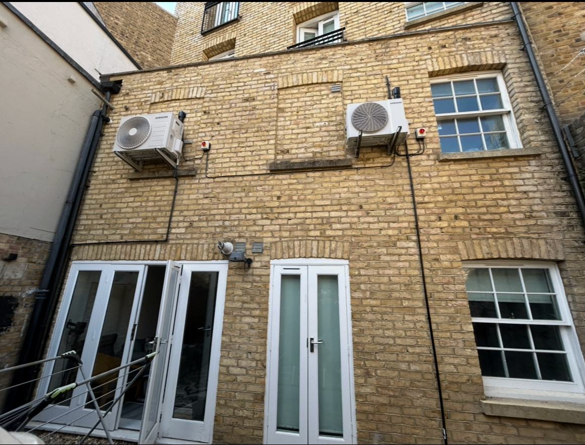 Exterior condenser units mounted on a brick wall
