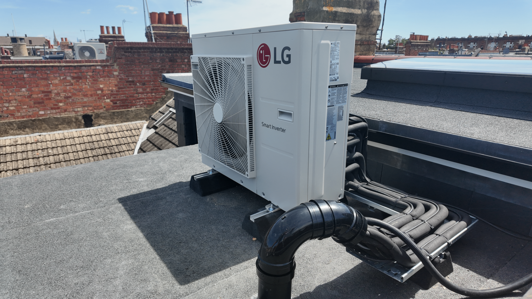 LG outdoor condenser installed on a Richmond rooftop with concealed pipework and flat roof supports